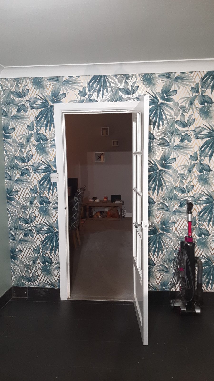 Doorway framed by blue and white palm leaf wallpaper