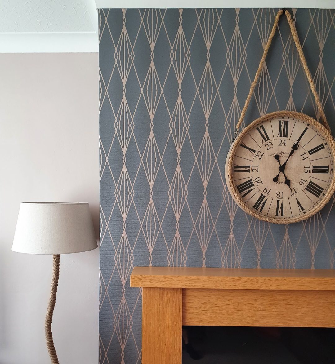 Geometric blue and rose gold feature wall with a rope hung clock