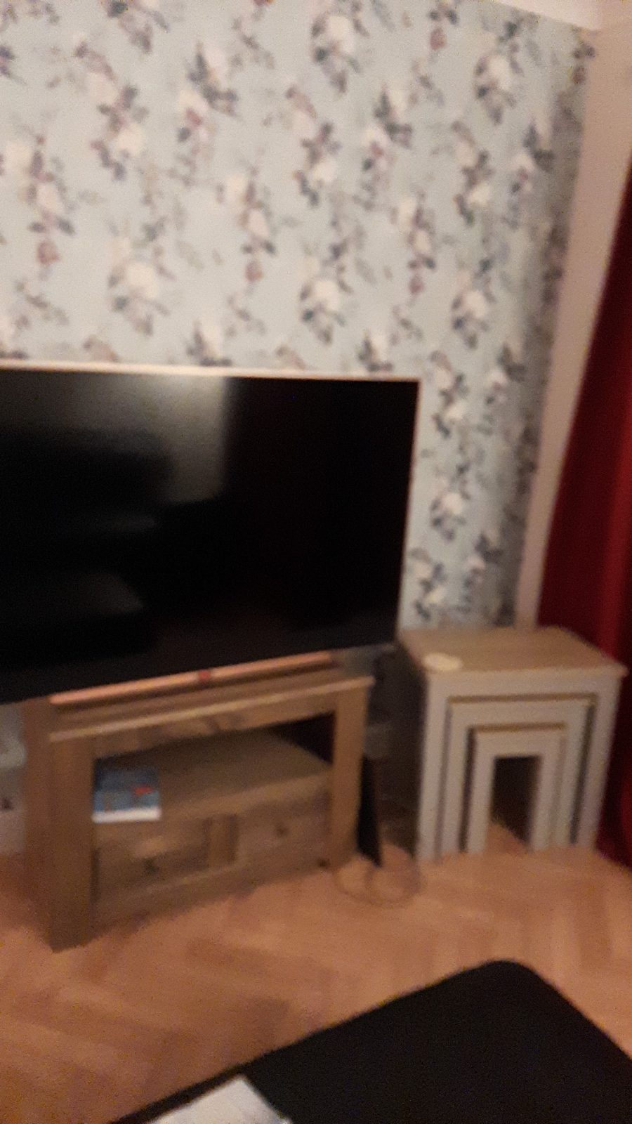 Soft floral wallpaper on a chimney breast in a living room